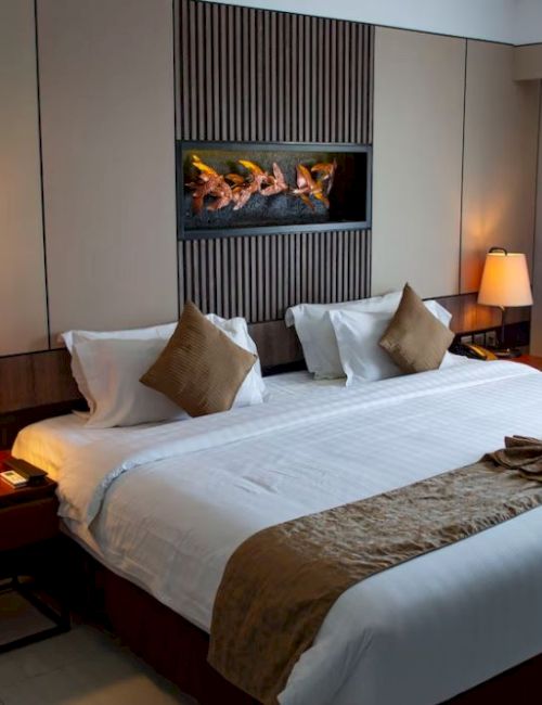 A neatly arranged hotel room with a large bed, two bedside lamps, and decorative pillows.